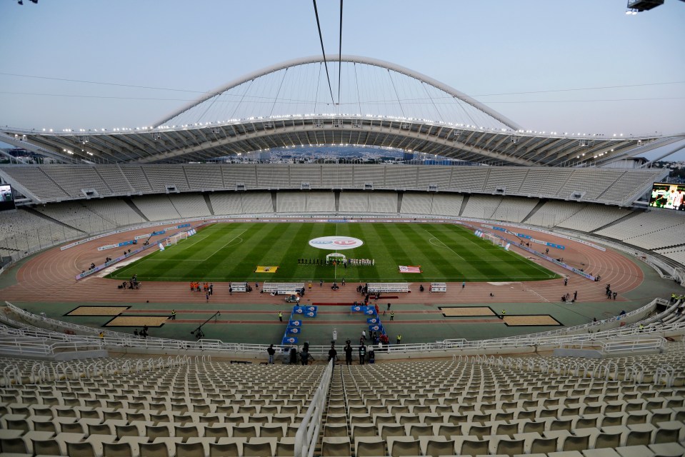 an empty stadium with a soccer field in the middle