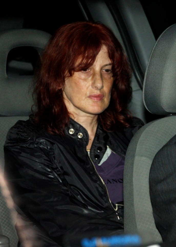 a woman with red hair is sitting in the back seat of a car