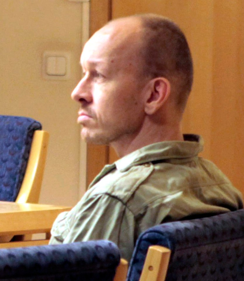 a man in a green shirt sits in a chair