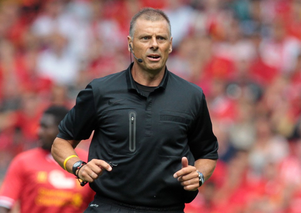 a referee wearing a nike shirt is running on the field