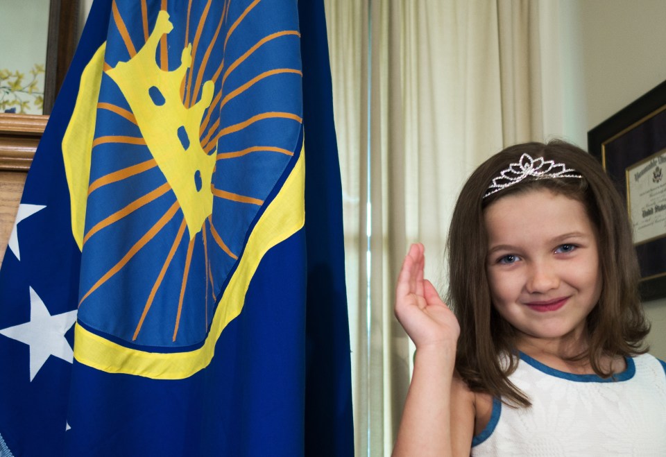 Jeremiah's daughter Emily posing next to the flag of the territory her dad 'claimed' for her