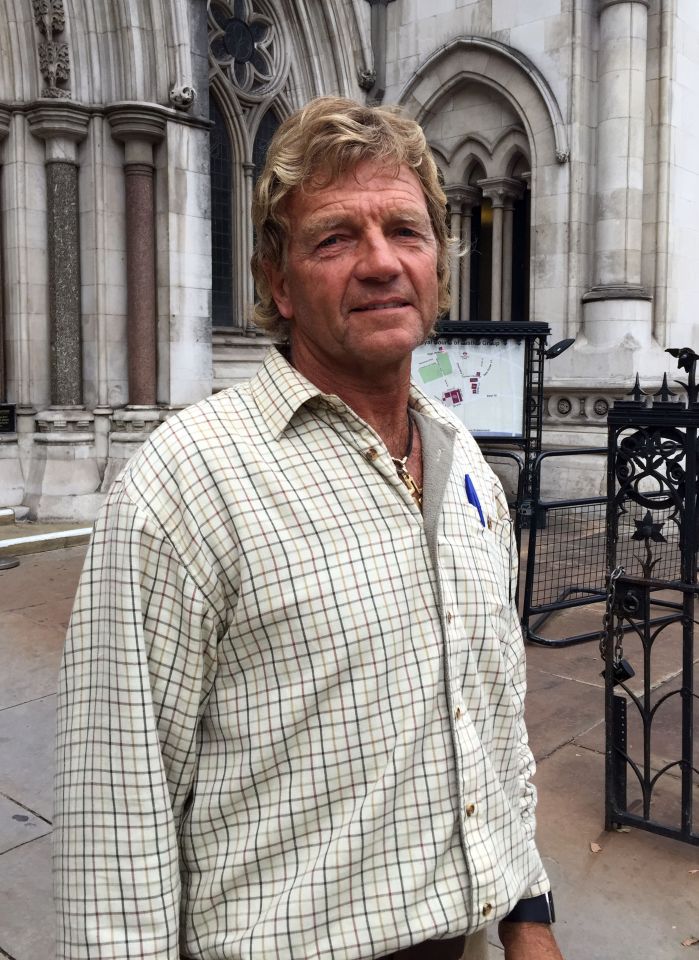 a man in a plaid shirt stands in front of a building