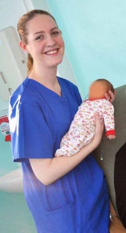 a nurse is holding a baby in her arms and smiling .