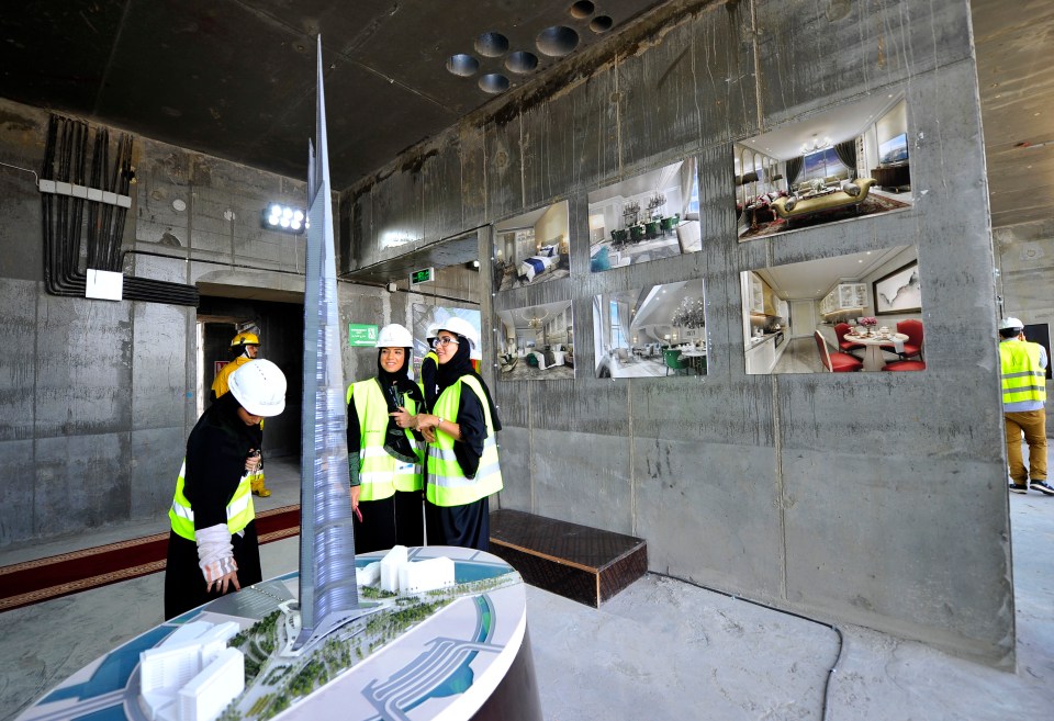 a group of people looking at a model of a building