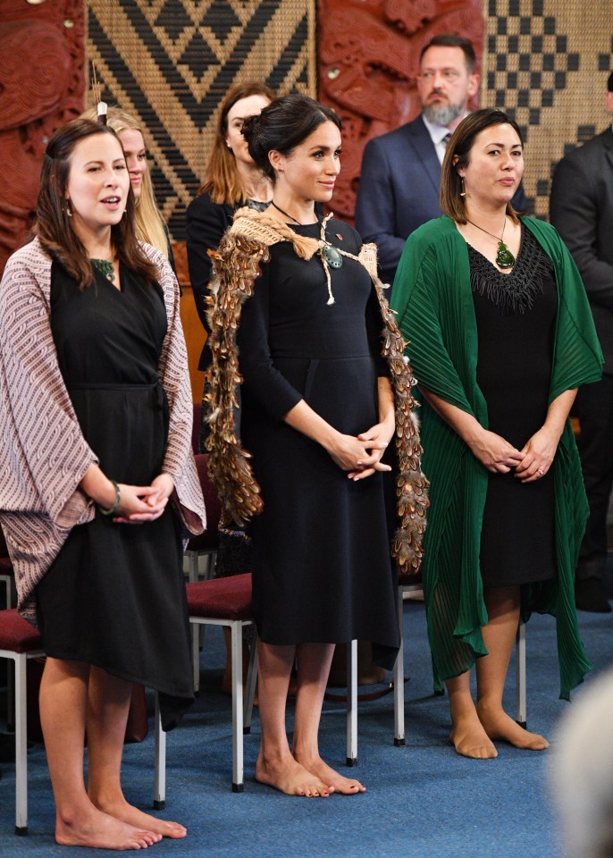 a woman in a black dress is standing next to two other women