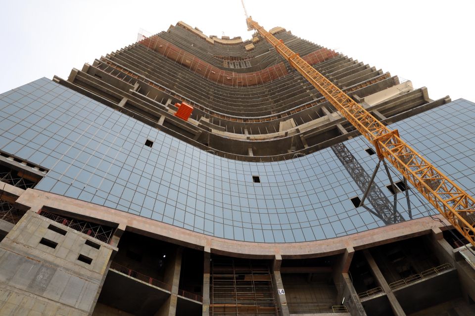 a very tall building under construction with a yellow crane in front of it