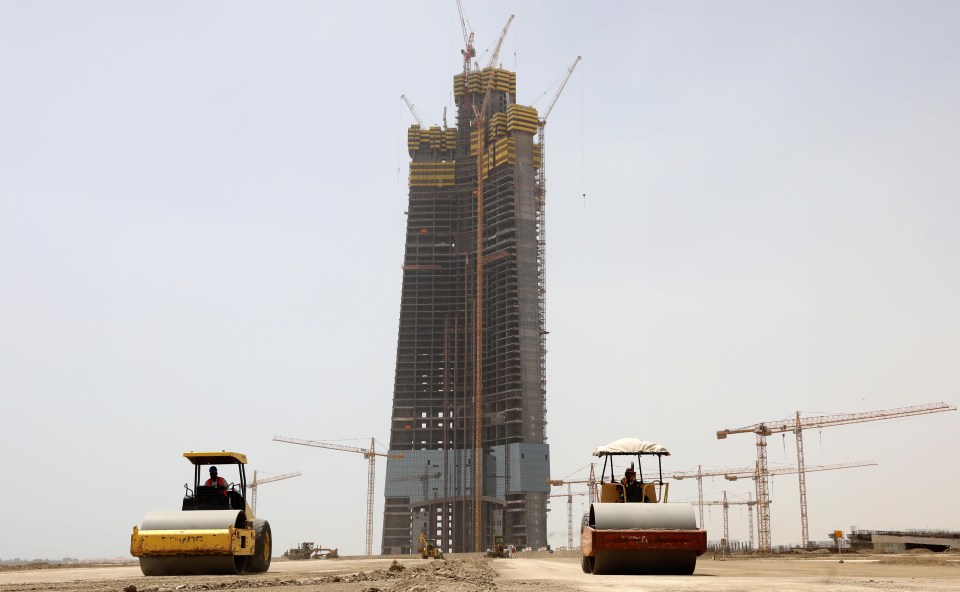 a construction site with a very tall building in the background