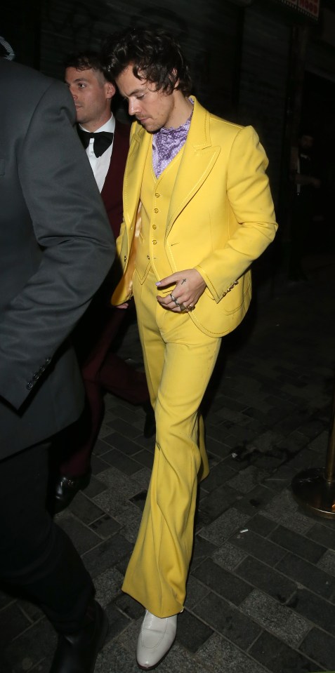 a man in a yellow suit is walking down the street