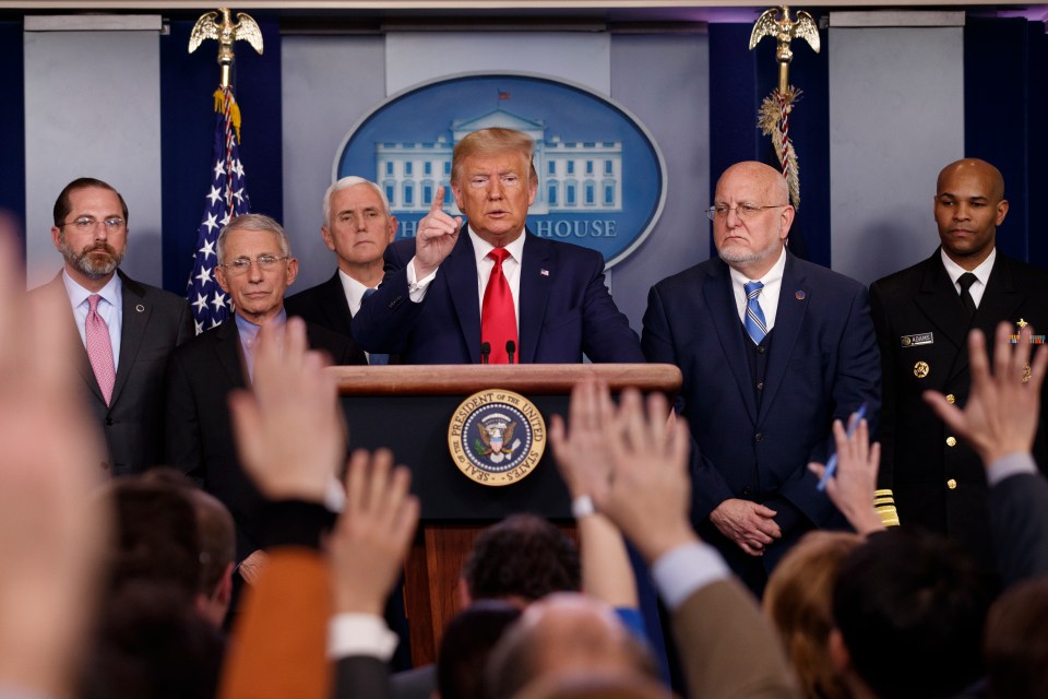 Donald Trump, centre, pictured with former CDC chief Dr Robert Redfield (right) and Anthony Fauci (left)