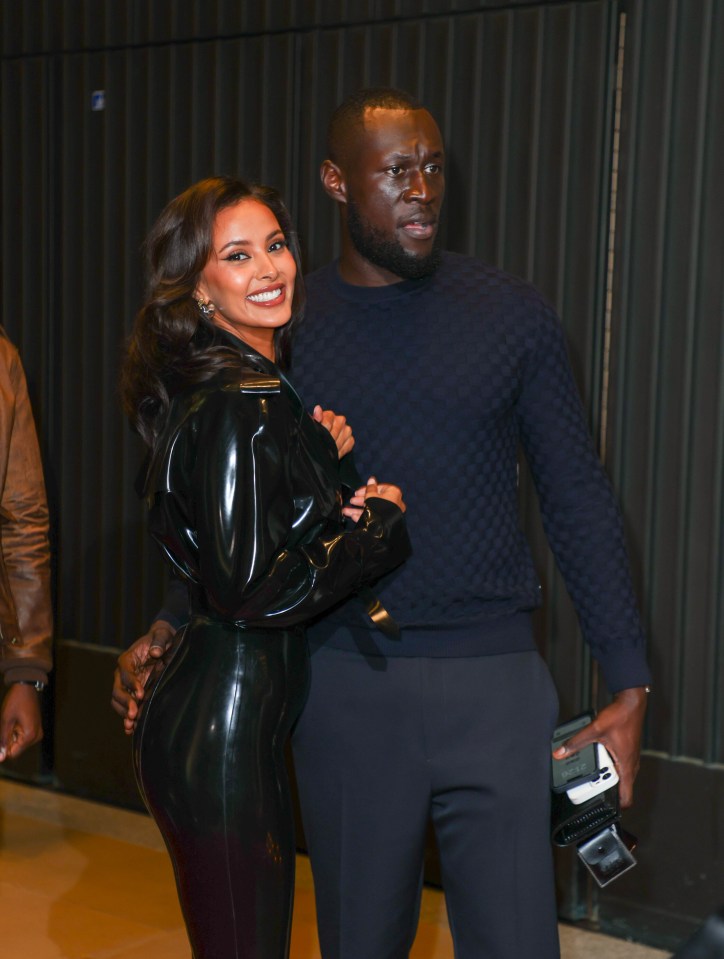 a man and woman posing for a picture with the man holding a camera