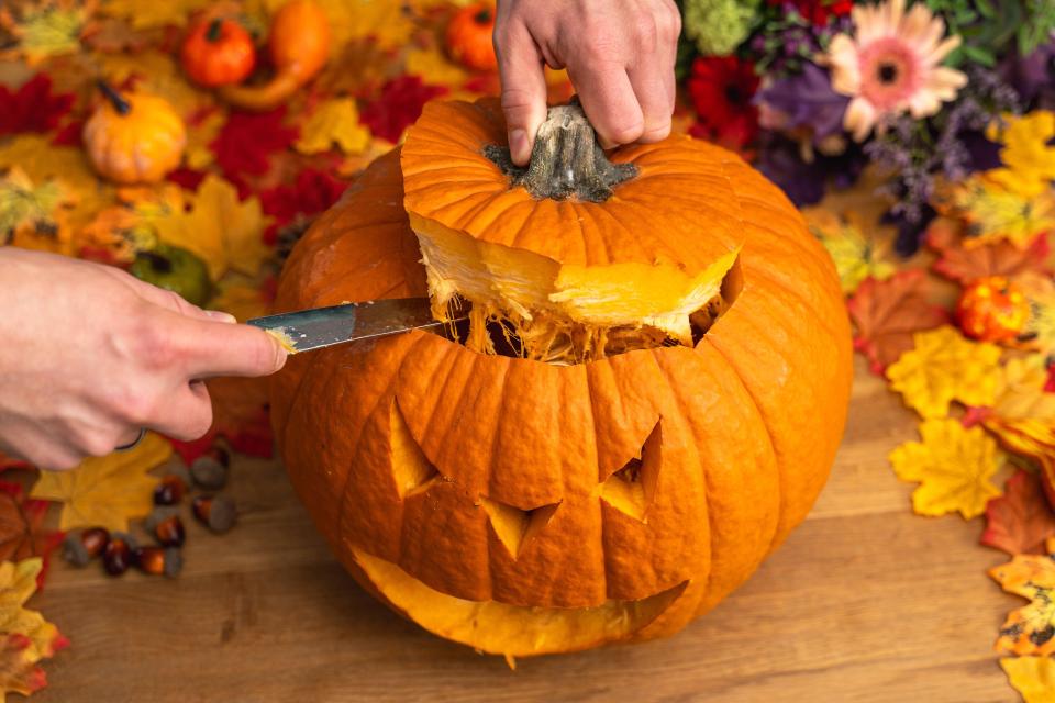 Once the face is carved, cut the lid out at an angle, so it will sit back on top, then scoop out the inside