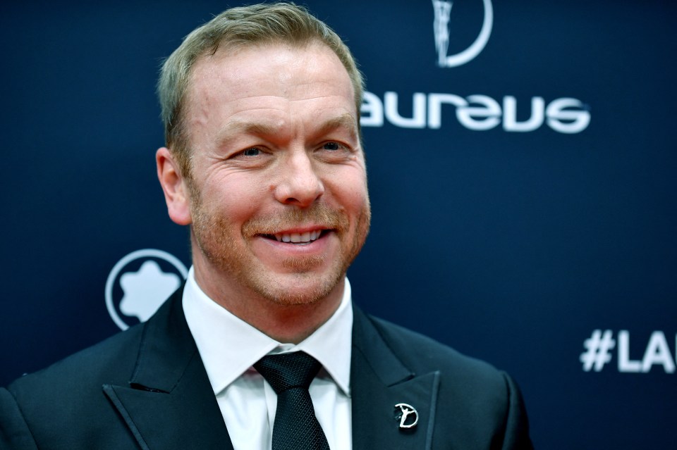 a man in a suit and tie is smiling in front of a sign that says aureus