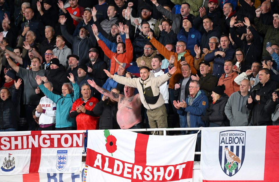 a group of people holding up a banner that says aldershot