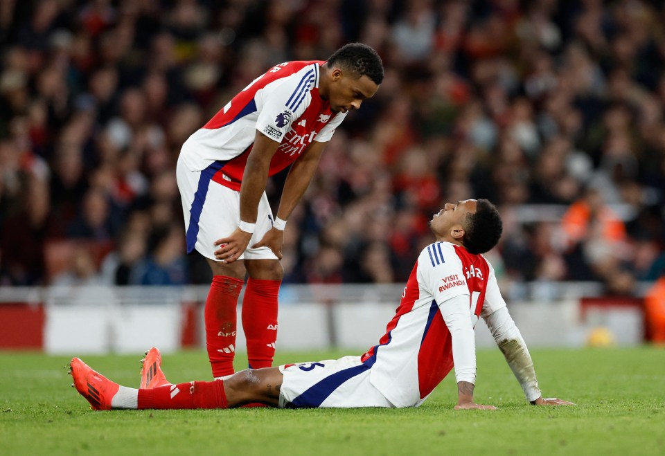 two soccer players on a field with one wearing a jersey that says fly emirates