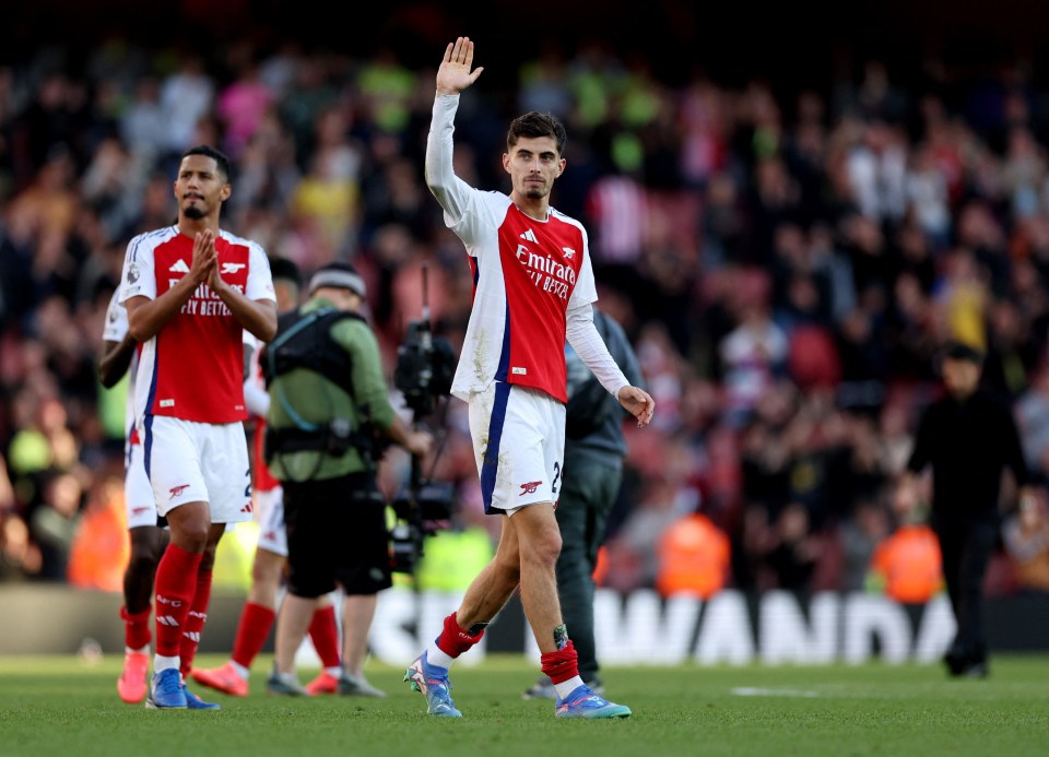 soccer player wearing a red and white jersey that says fly emirates