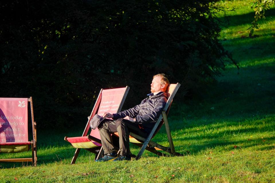 a man sits in a chair with a sign that says " love today and laugh tonight "