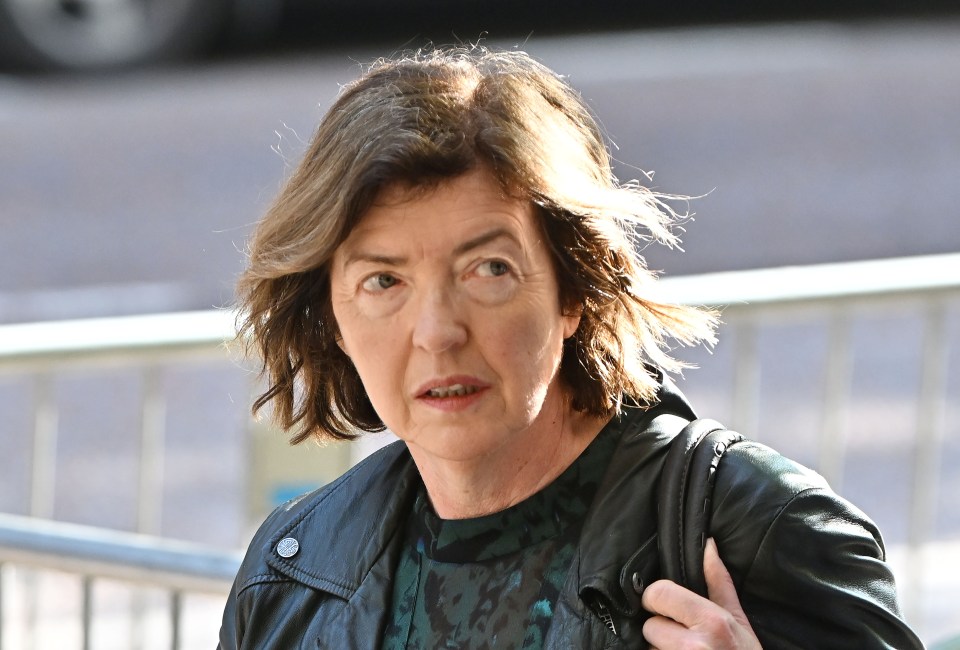 a woman wearing a black leather jacket is walking down the street