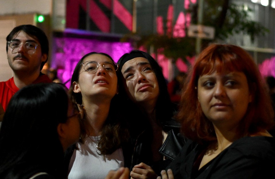 Fans cry as they wait outside the hotel