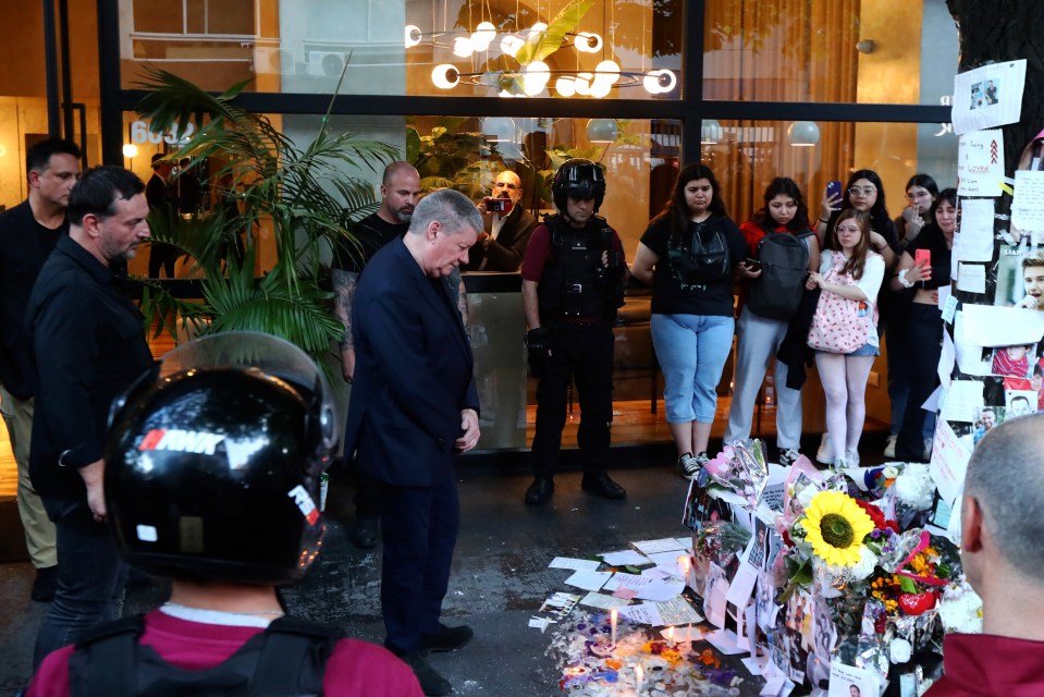 Geoff looks down at the masses of flowers, cards and candles left out to honour his son Liam