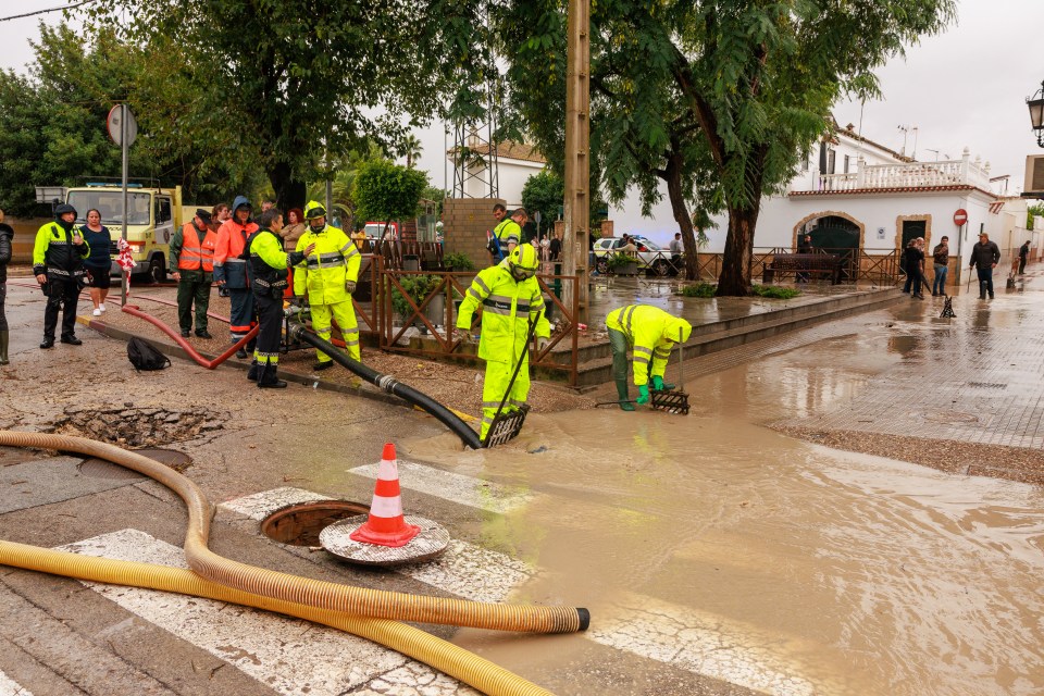 Firefighters and police officers work after heavy flooding