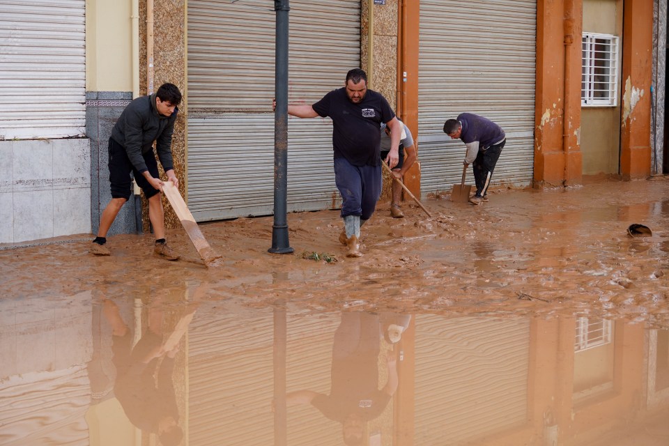 Residents clean the roads after extreme flooding