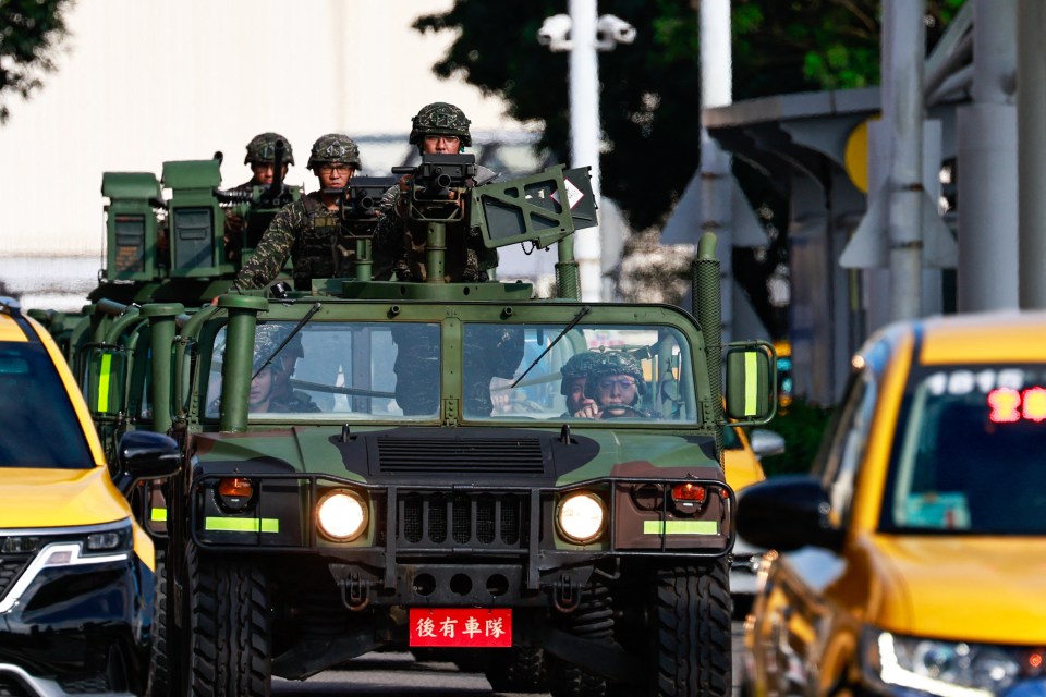 Military vehicles patrol outside Songshan Airport in Taipei as China deploys fighter jets and warships to encircle the island