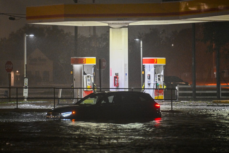 A vehicle stranded on a water-flooded street after Hurricane Milton made landfall in Brandon, Florida