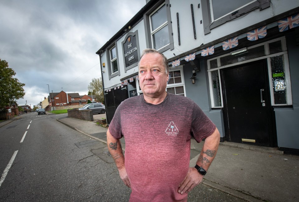 a man in a red shirt stands in front of a building that says the aldston arms