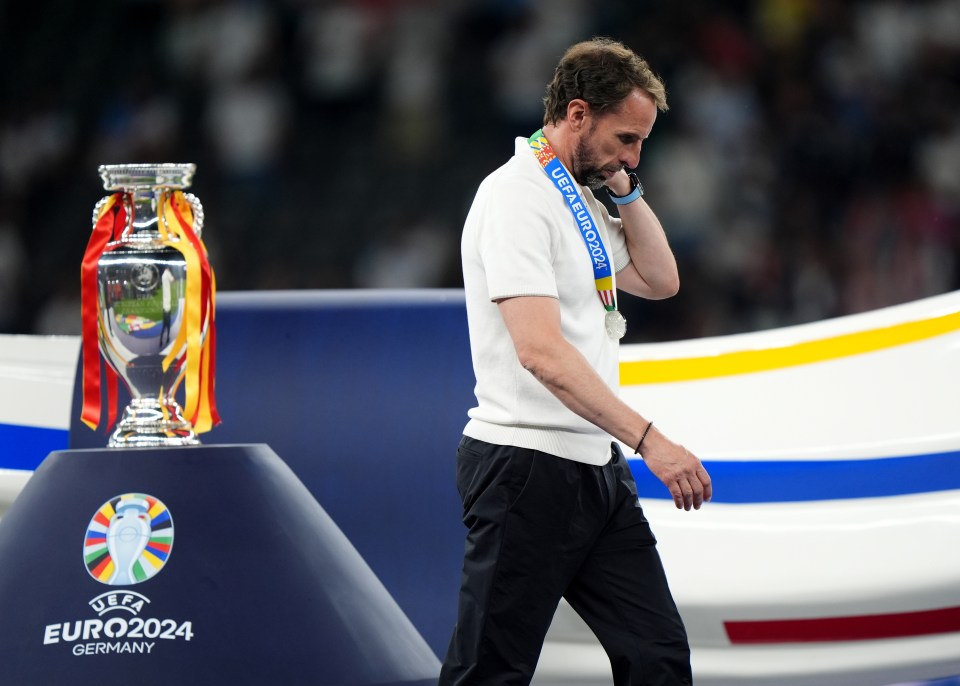 a man stands in front of a trophy that says euro2024