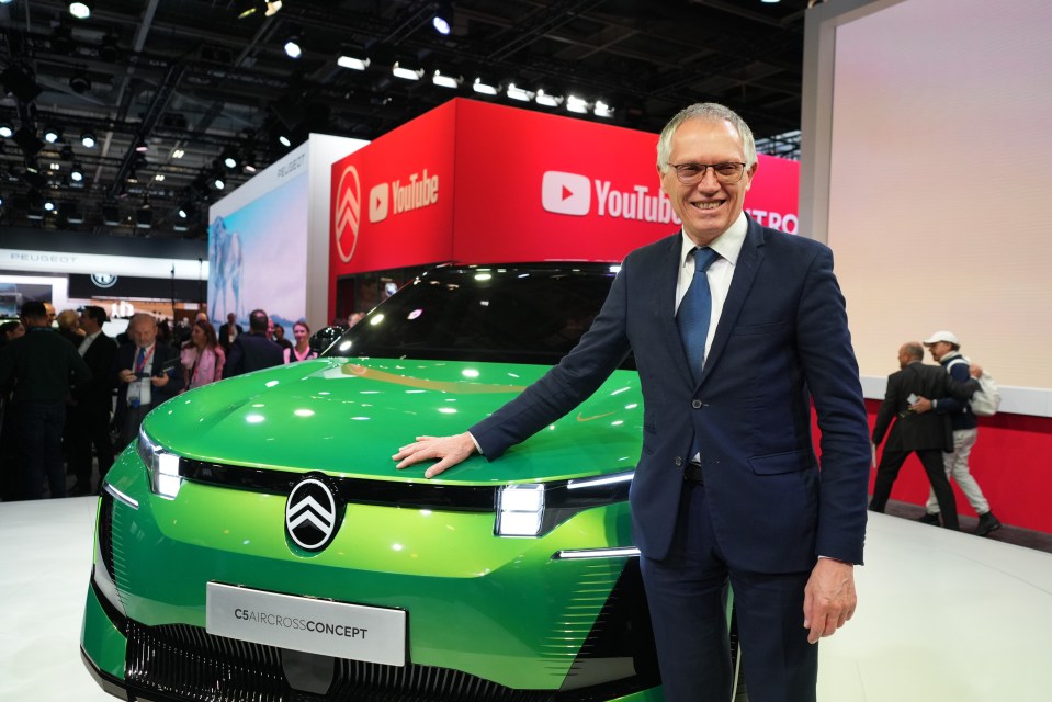 a man stands in front of a green car that says cs microcross concept