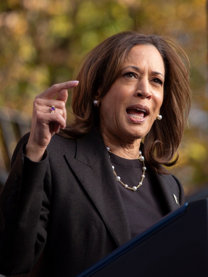 a woman wearing a black jacket and pearls is making a funny face