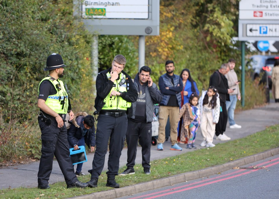 a group of people standing in front of a sign that says birmingham