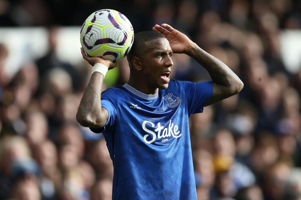 a man in a blue stake jersey holds a soccer ball over his head