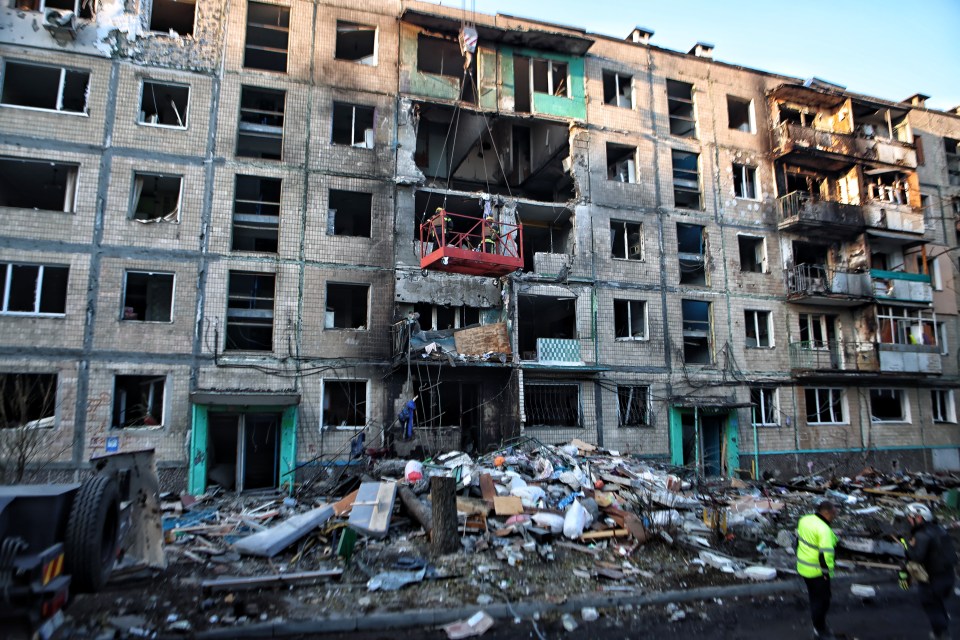 A rescuer clears debris in a residential high-rise building after a Russian airstrike on October 3, 2024 in Kharkiv, Ukraine