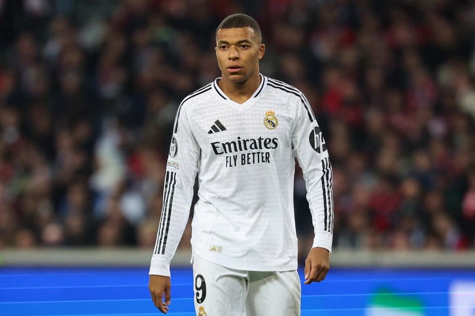 a soccer player wearing a white emirates fly better jersey