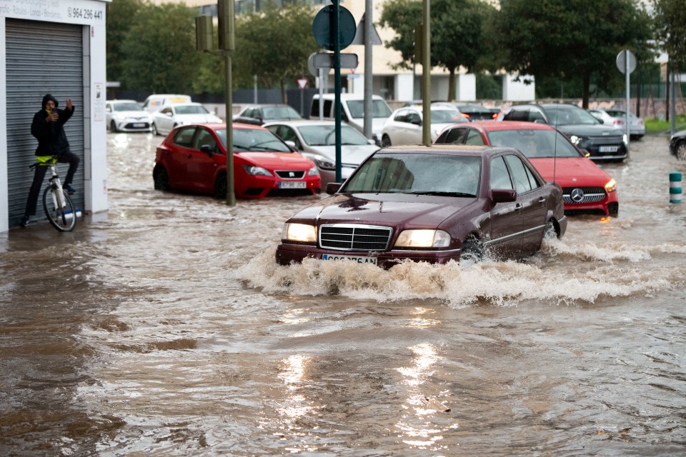 Cars struggle to make it through the deep rain water