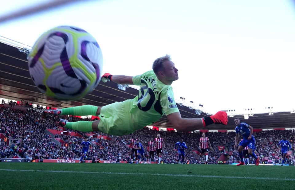 a soccer player wearing number 30 dives to catch a ball