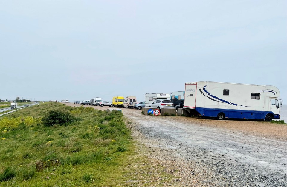 a row of rvs are parked on a gravel road