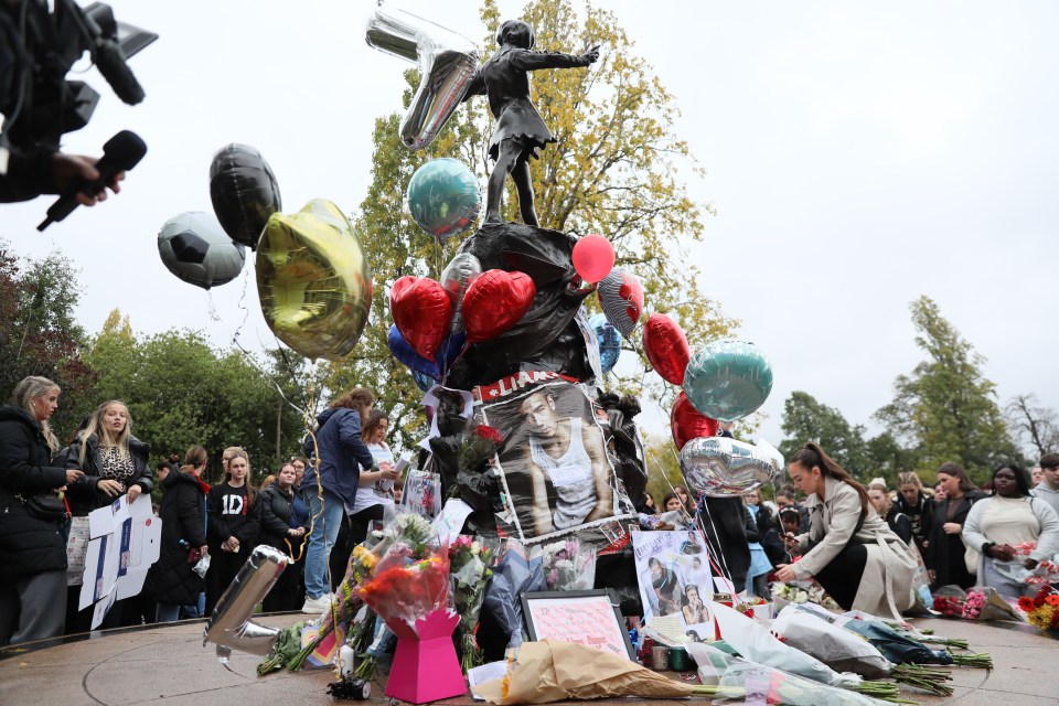 Fans gathered around flowers and balloons at the memorial in Hyde Park