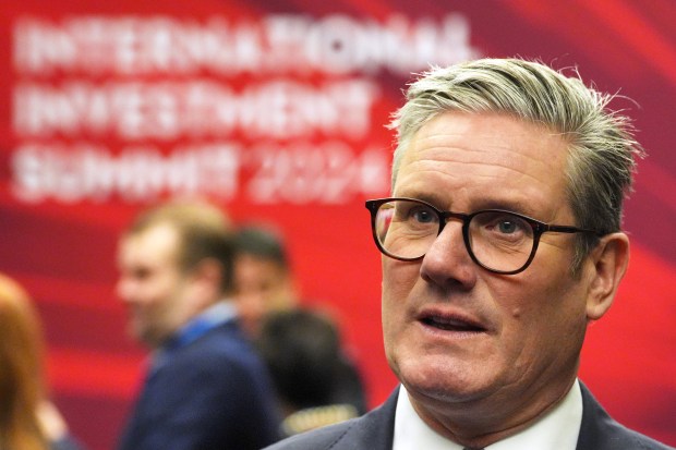 a man wearing glasses and a suit stands in front of a sign that says ' no final investment summit '