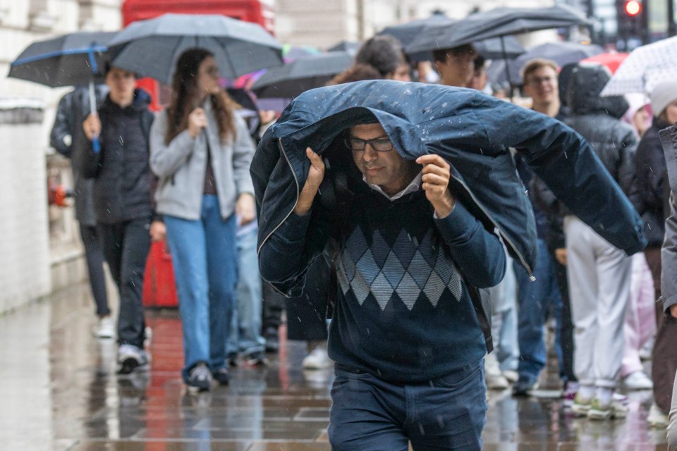 Londoners try to shelter from the rain in Westminster, London, last week