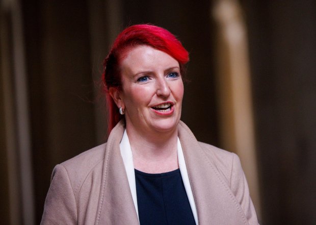 a woman with red hair and blue eyes is smiling