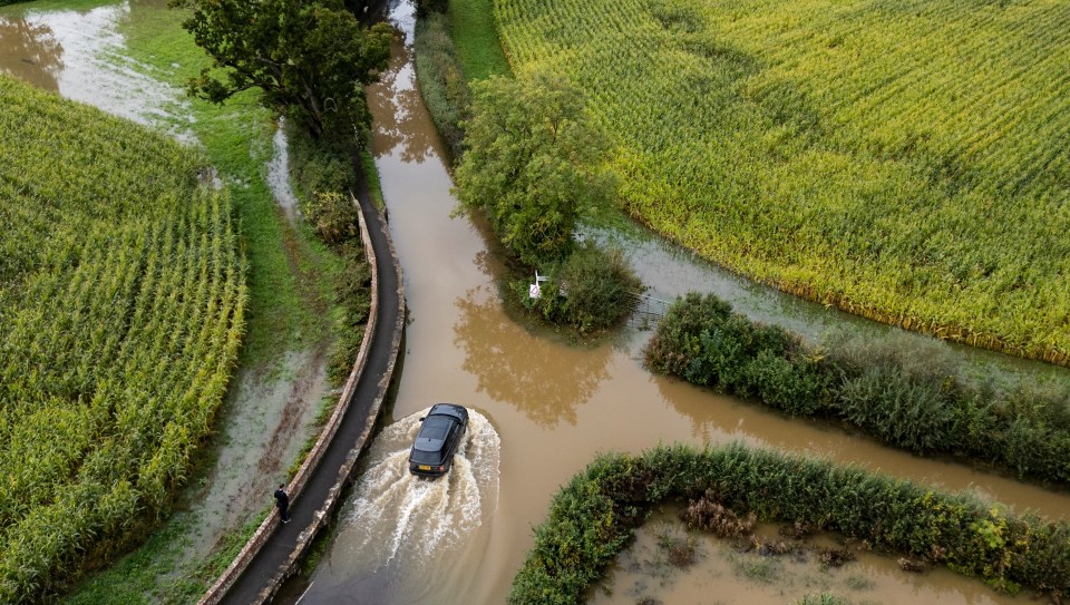 Cars navigating flooded roads near Kellaways in Wiltshire yesterday