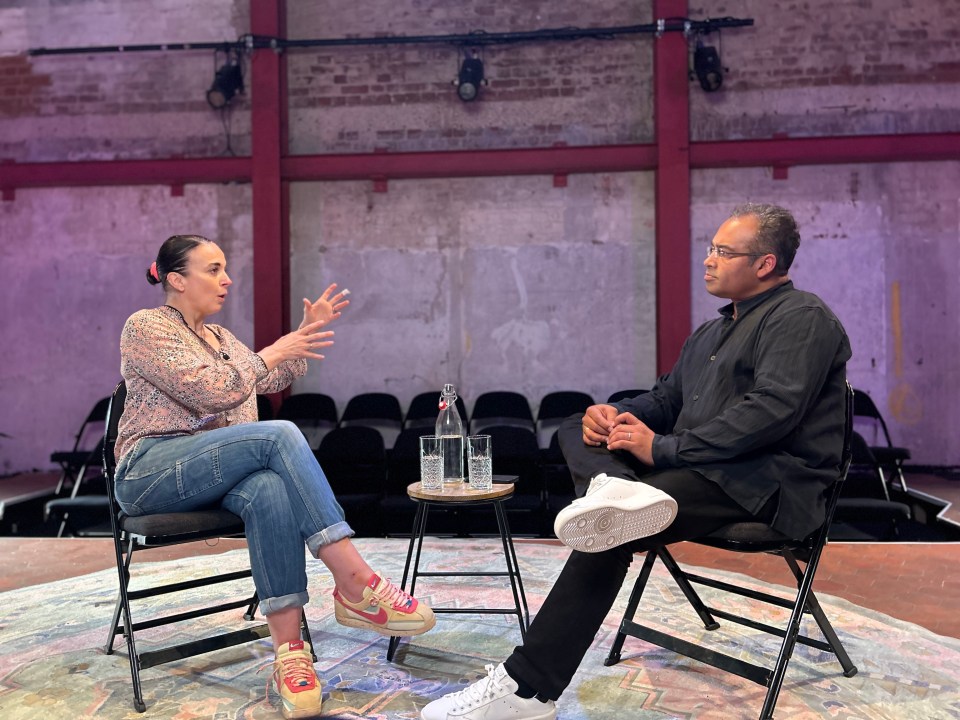 a man and a woman are sitting in chairs talking to each other