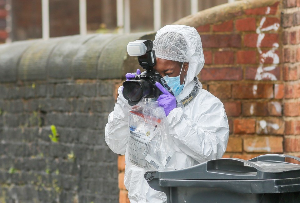 a woman in a protective suit is taking a picture with a nikon camera