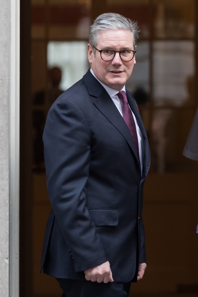 a man in a suit and tie stands in a doorway