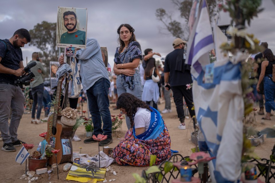 People commemorate the one-year anniversary since October 7 at the Nova festival grounds