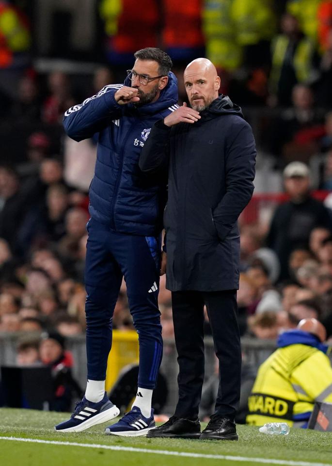 two men on a soccer field with one wearing a jacket that says adidas