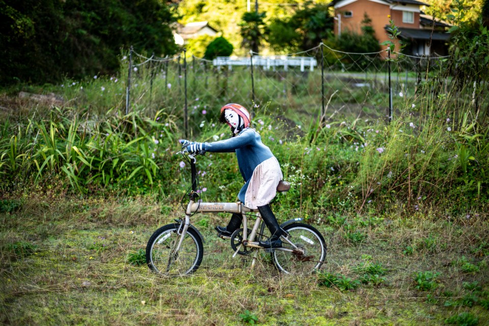 Another doll riding a bike in the village