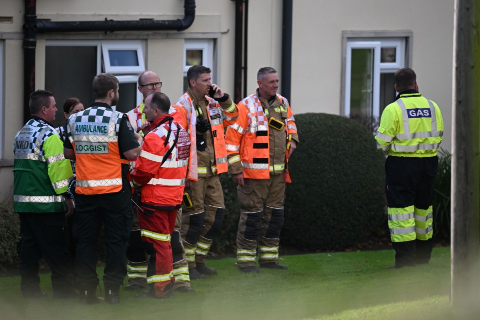 a group of emergency workers including an ambulance and a gas worker